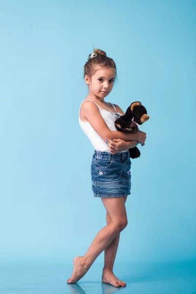 Roztomilá holčička na modrém pozadí — Stock fotografie