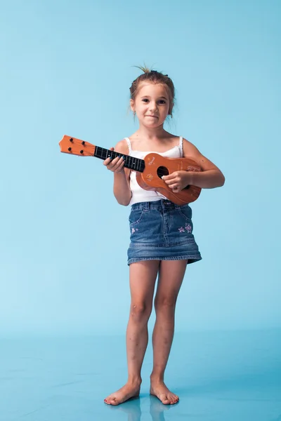 Schattig klein meisje op blauwe achtergrond — Stockfoto