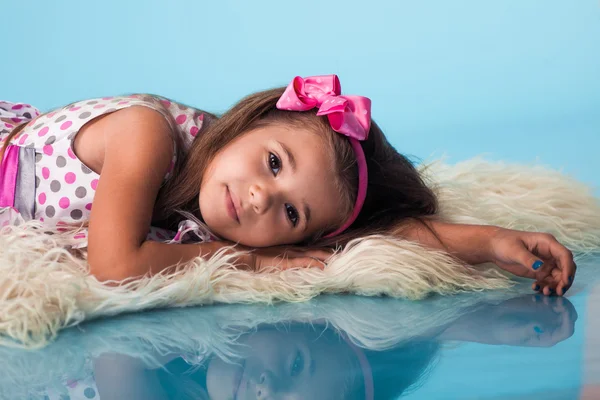 Niedliches kleines Mädchen auf blauem Hintergrund — Stockfoto