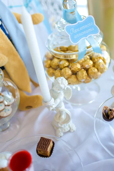 Candies in a glass jar with a blue ribbon and the words "bon appetit" — Stock Photo, Image