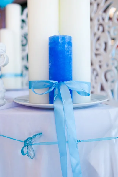 Modré a bílé svíčky svázané stuhou na stůl — Stock fotografie