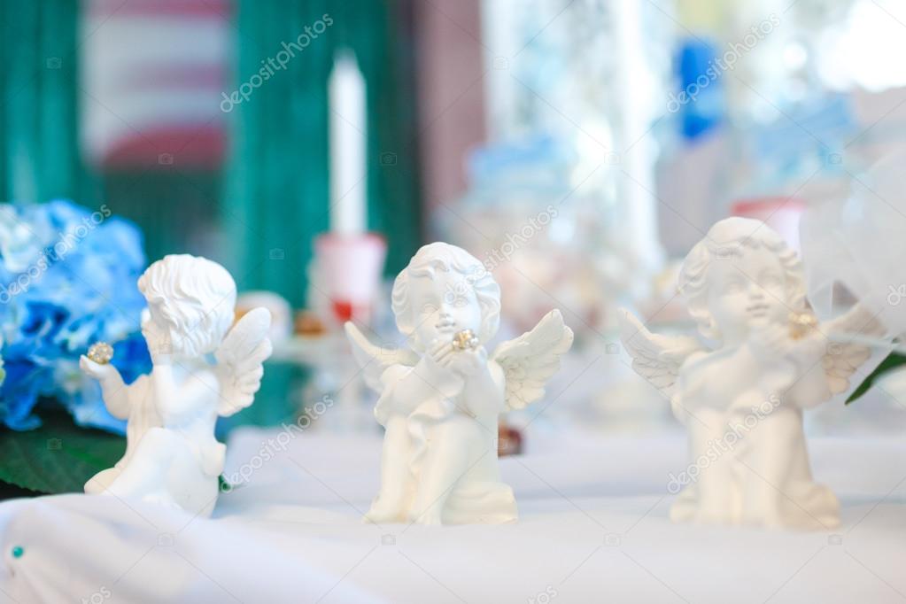 Three statues of angels on the table