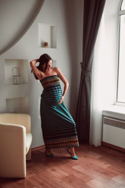 hamile kadının ellerini karnına koydu.