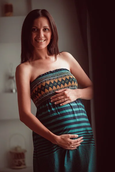 Zwangere vrouw legde haar handen op een buik — Stockfoto