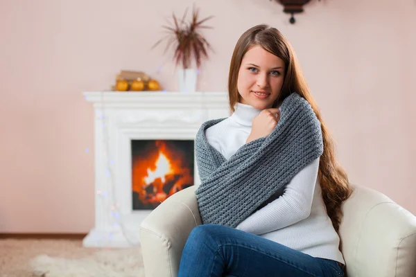 Dziewczyna siedzi przy kominku — Zdjęcie stockowe