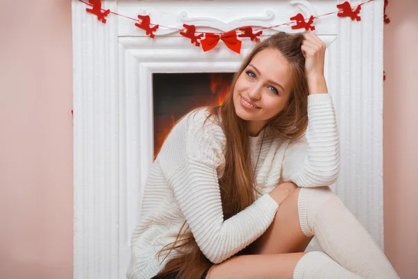 Girl sitting beside the fireplace — Stock Photo, Image
