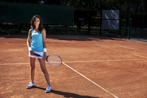 Mladá dívka hraje tenis v krásné počasí — Stock fotografie
