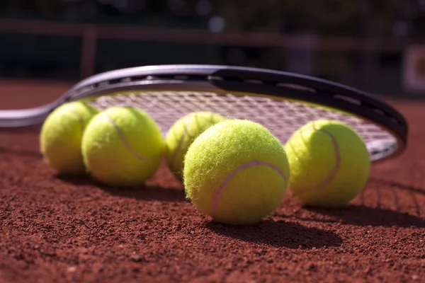 Tennisbollar och raket på domstolen fältet — Stockfoto