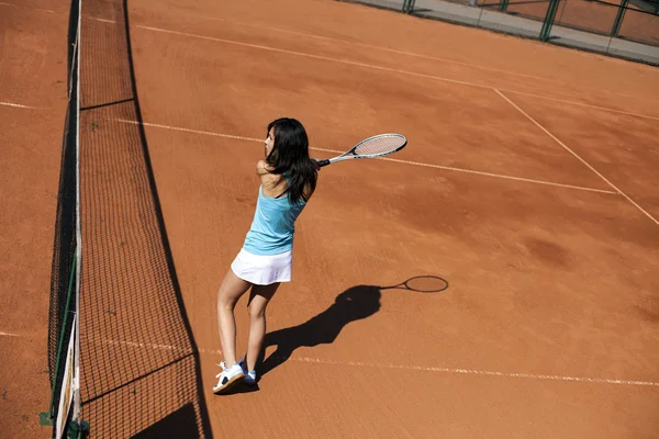 Chica joven jugando al tenis en la cancha —  Fotos de Stock