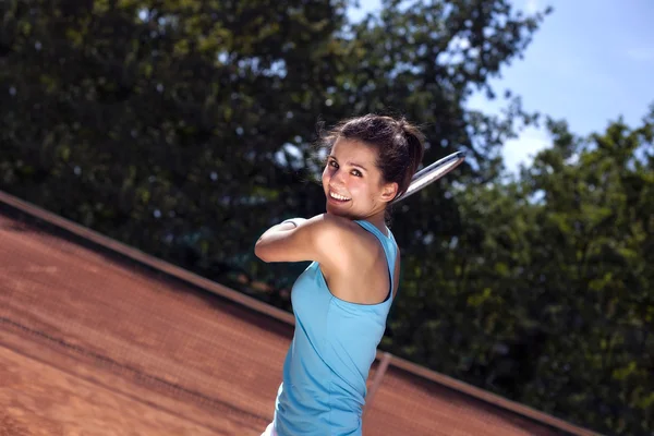 Ung flicka spela tennis på domstolen — Stockfoto