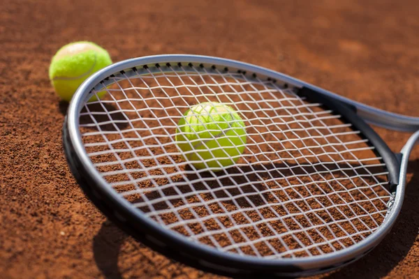 Tennis balls and rocket on court field — Stock Photo, Image