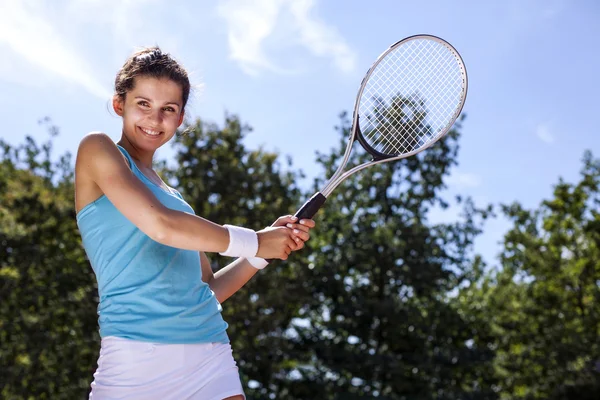 Mladá dívka hraje tenis v krásné počasí — Stock fotografie