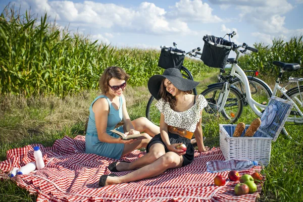 Zwei hübsche Mädchen ejnoy die Sonne im Picknick — Stockfoto