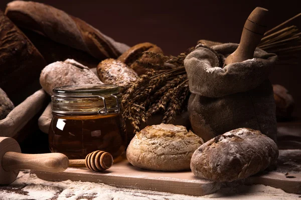 Vers brood en tarwe op de houten tafel — Stockfoto