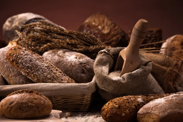 Pan fresco y trigo en la mesa de madera — Foto de Stock