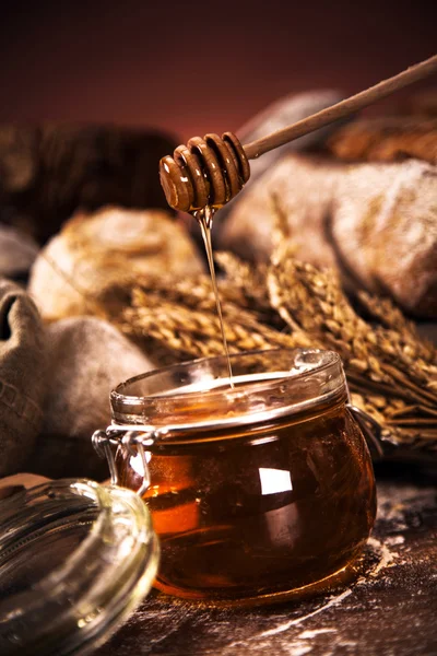 Fresh bread and wheat on the wooden table — Stock Photo, Image