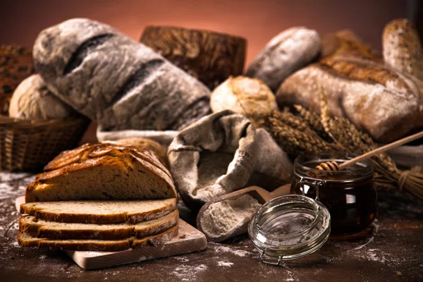 Tahta masada taze ekmek ve buğday. — Stok fotoğraf