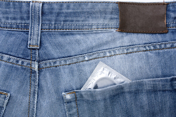Close-up old jeans and a condom in his back pocket