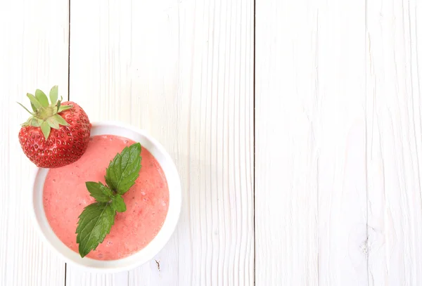 Heller Holzhintergrund mit einem Erdbeer-Dessert — Stockfoto