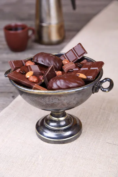 Cioccolato in un vaso di metallo su uno sfondo di tela grigia — Foto Stock