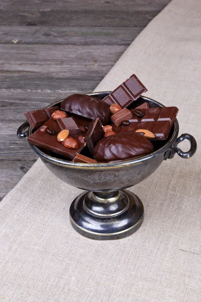 Chocolate em um vaso de metal em um fundo de lona cinza — Fotografia de Stock