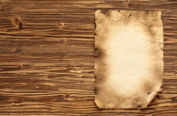 Old paper on brown wooden background — Stock Photo, Image