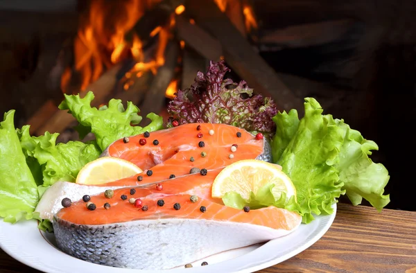 Due bistecche di salmone sullo sfondo di una fiamma ardente — Foto Stock