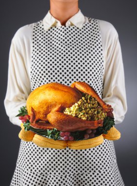 Homemaker Holding Turkey on a Platter clipart