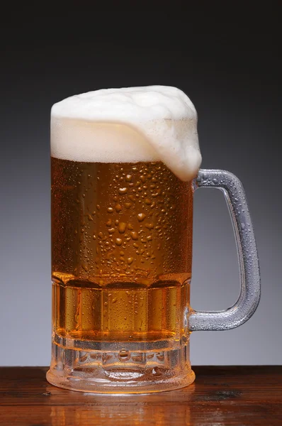 Tazza di birra sulla superficie di legno bagnato — Foto Stock