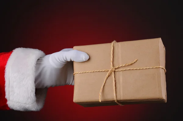 Weihnachtsmann hält ein Paket in der Hand — Stockfoto