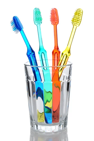 Четыре зубные щетки в стекле — стоковое фото