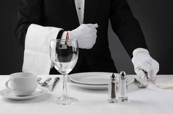 Waiter Setting Formal Dinner Table