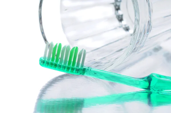 Grüne Zahnbürste mit Glas — Stockfoto