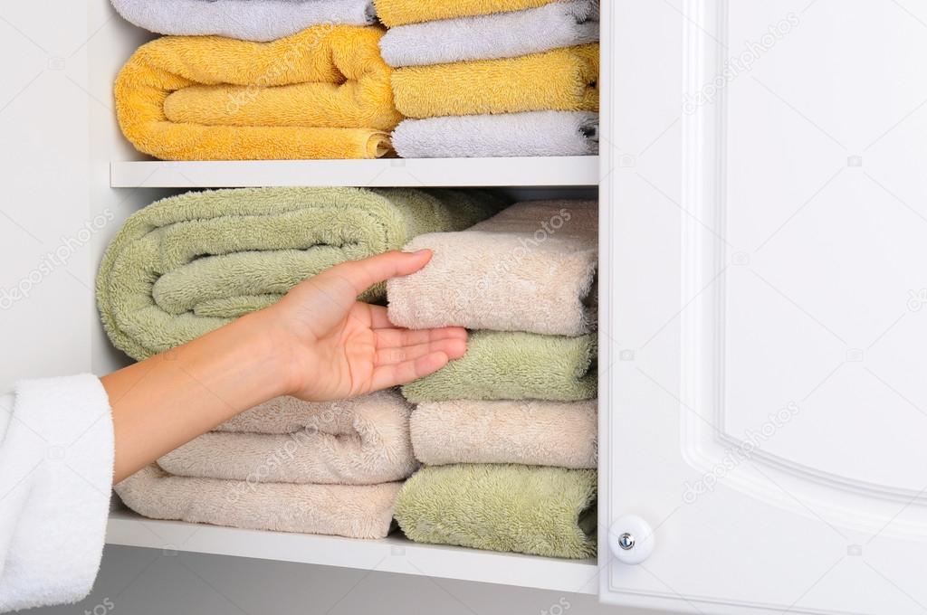 Woman Taking Towel From Linen Closet