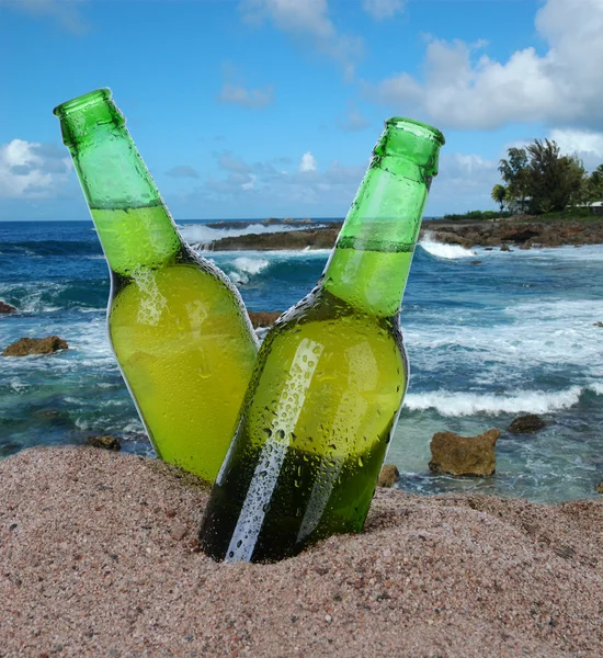 Бутылки пива на песке — стоковое фото