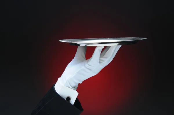 Kellner mit silbernem Serviertablett in den Fingerspitzen — Stockfoto