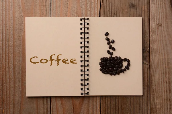 Feijões de café em caderno aberto — Fotografia de Stock
