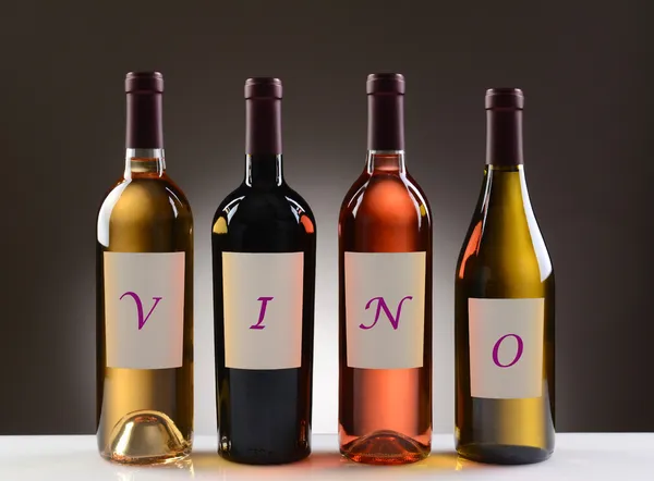 Wijnflessen met etiketten spelling uit vino — Stockfoto