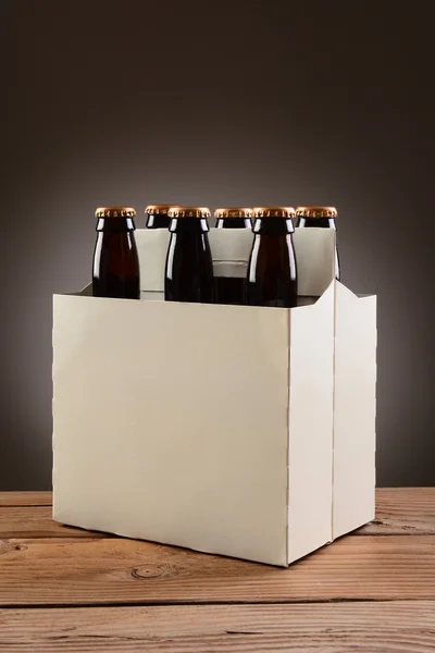 Шість упаковок пива на дерев'яний стіл — стокове фото