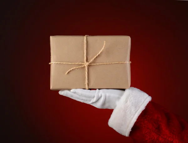 他的手掌里拿着一个包裹的圣诞老人 — 图库照片