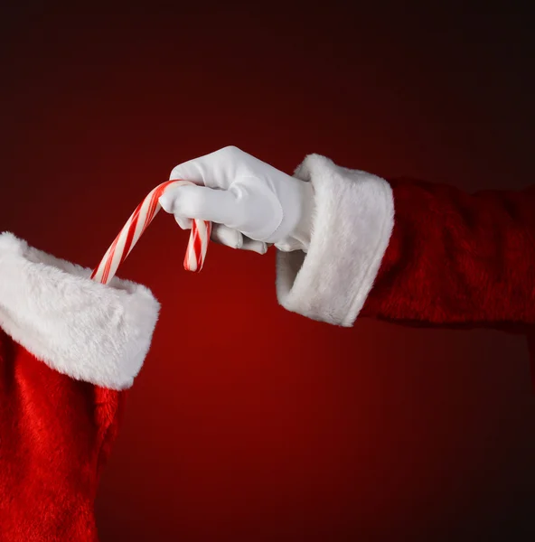 将糖果手杖放进袜子里的圣诞老人 — 图库照片