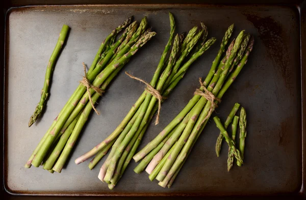 Trossen van asperges op koken blad — Stockfoto