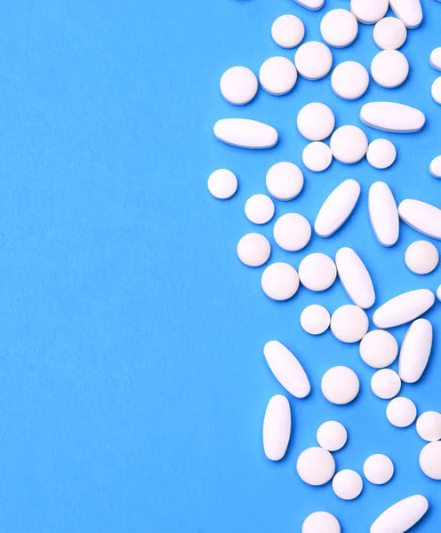 Białe tabletki na niebieski backgorund — Zdjęcie stockowe