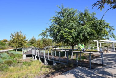 IRVINE, CALIFORNIA - 27 OCT 2021: Büyük Park patikalarında yükseltilmiş tahta yürüyüş, Yukarı Arı ve Bosque bölgesinde 1,5 mil yürüme ve bisiklet alanı.