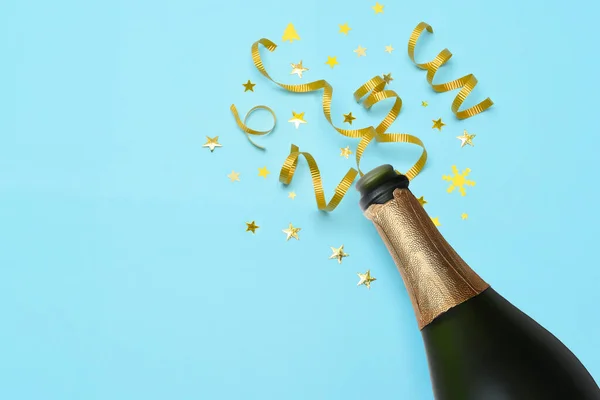 Een Champagne Fles Zijn Kant Met Slingers Gouden Sterren Lichtblauw — Stockfoto