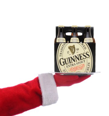 IRVINE, CALIFORNIA - 14 Aralık 2021: Noel Baba elinde 6 paket Guinness Stout ile servis tepsisi tutuyor.