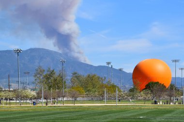 IRIVNE, CALIF - 2 MAR 2022: Orange County Büyük Parkı 'ndan görülen, Cleveland Ulusal Ormanı' ndaki Saddleback Tepesi 'ndeki bir yangından duman yükseliyor..