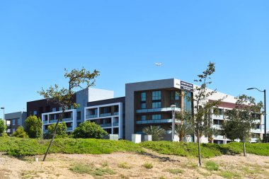 TÜSTİN, CALIFORNIA - 12 HAZİRAN 2022: Redhill Bulvarı 'ndaki daireler ve John Wayne Havaalanı' na yaklaşan jet uçakları. 