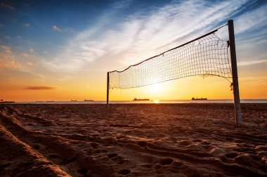 Volleyball net and sunrise on the beach clipart
