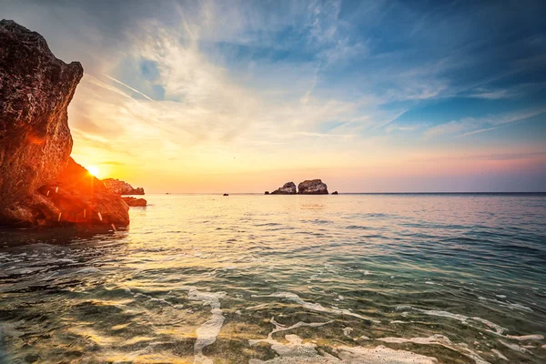 Puesta de sol tropical colorida en la playa de piedras . —  Fotos de Stock